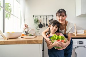 Portrait,of,asian,mother,stand,with,daughter,and,hold,vegetables